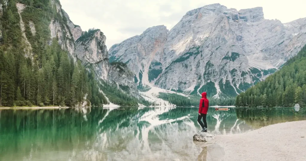 A traveller at the edge of a mountain lake