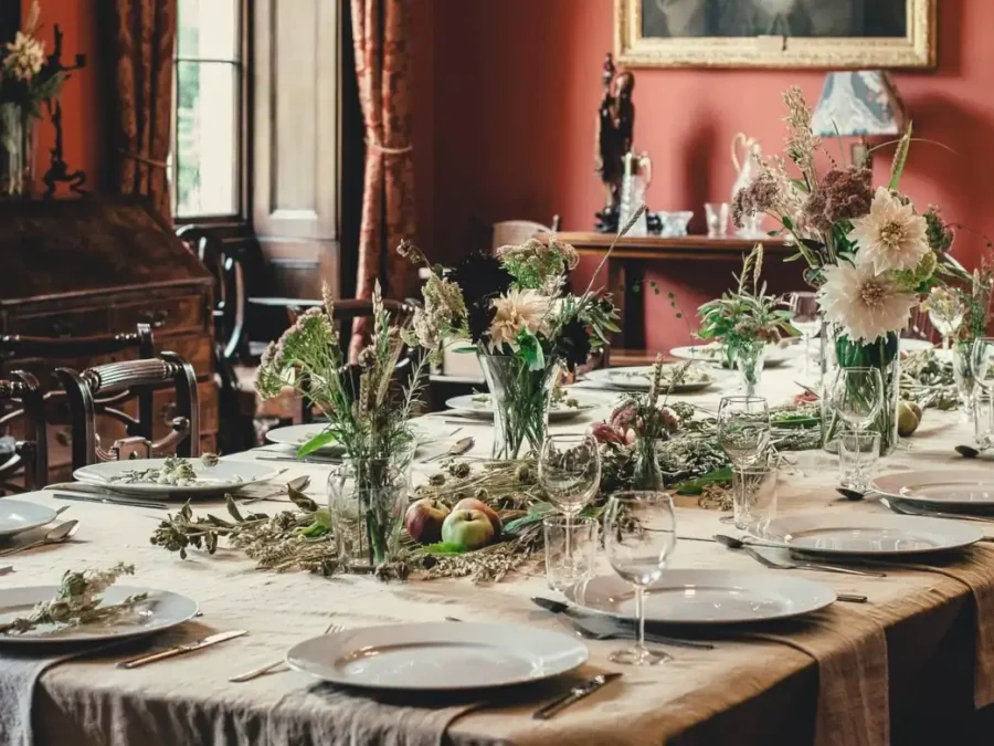 A long dinner table decorated with flowers