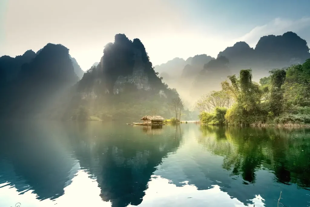 Misty limestone mountains reflected in a calm lake